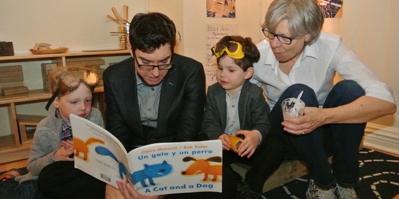Picture of man and woman reading to two children