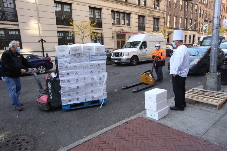 A man wheels a flat of boxes that contain frozen turkeys.