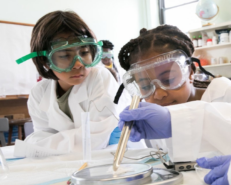 Children conducting science experiments with goggles.