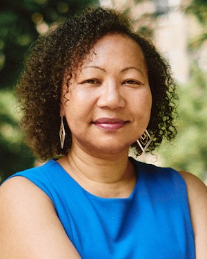 A woman with curly hair in a blue shirt