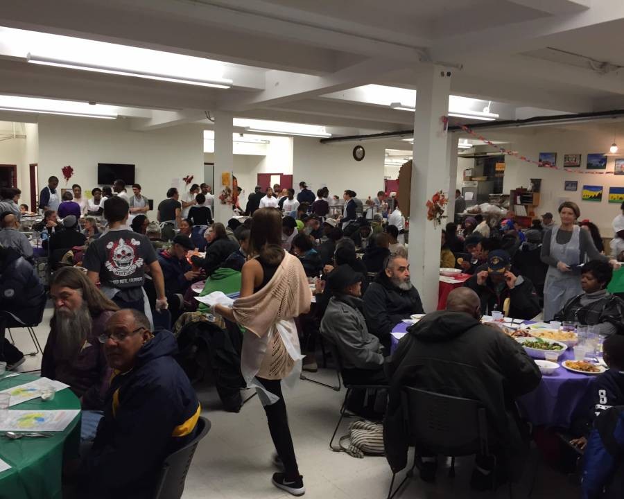 A crowded room with many tables of people eating.